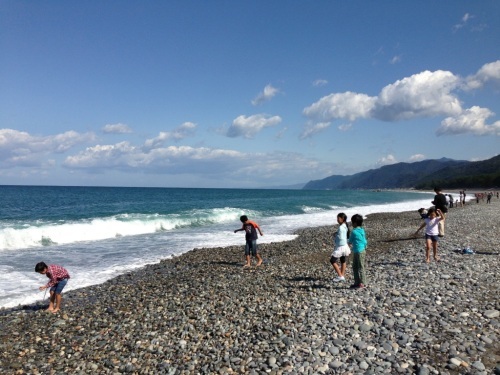 子供たちがヒスイ海岸の波打ち際で遊んでいる様子